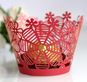 Intricate red laser-cut floral cupcake wrappers for elegant wedding dessert table decoration