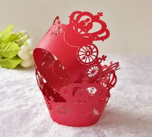 Detail of red hollow laser-cut cake lace wrap featuring pumpkin carriage and crown design