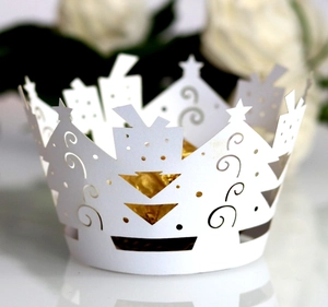 Intricate laser-cut white paper crown cake wrappers with star patterns for Christmas party