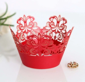 Detail of red laser-cut cupcake wrapper with intricate lace patterns for weddings