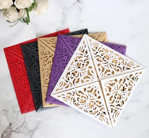 Macro detail of laser-cut floral wedding invitations in diverse pearlescent colors