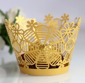 Macro shot of gold laser-cut cupcake wrapper with floral pattern for candy decoration