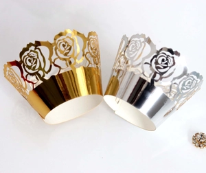 Detail of laser-cut rose hollow cupcake wrappers in metallic gold and silver finish