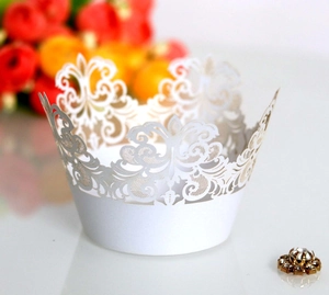 Detail of white laser-cut crown lace cupcake wrappers with elegant hollowed-out pattern