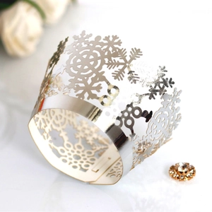 Golden laser-cut snowflake cupcake wrappers with a metallic mirror finish for weddings