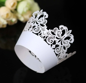 Macro shot of white laser-cut cupcake wrappers with intricate baroque filigree hollow patterns