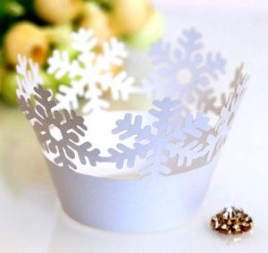 Macro shot of laser-cut white snowflake cupcake liners with elegant crown design