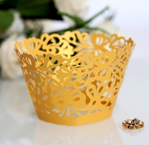 Detailed laser-cut gold cupcake wrapper with intricate butterfly and vine hollow patterns