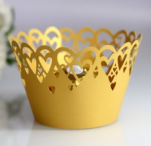 Detailed laser-cut heart pattern on gold pearlescent paper cupcake wrappers for weddings