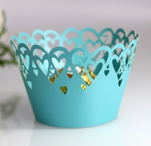 Detail of light blue laser-cut heart pattern cupcake wrappers with gold foil chocolate