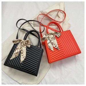 Détail du sac à main matelassé avec nœud en foulard et bandoulière amovible