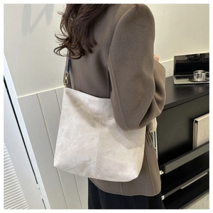 Détail du sac cabas gris avec sa large bandoulière tissée colorée et ses ferrures dorées