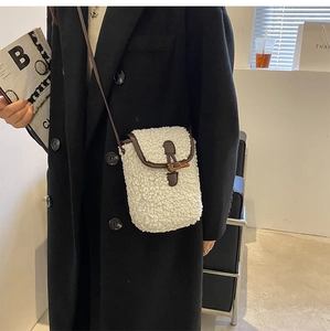 Détail du sac bandoulière en peluche blanche avec boucle corne et cuir brun