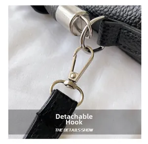 Detail of silver detachable swivel hook and D-ring on black lychee leather bag
