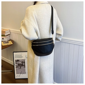 Détail du sac demi-lune noir en cuir grainé avec double zip et bandoulière réglable