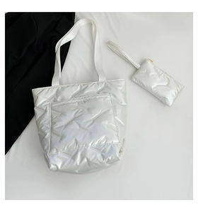 Detailed macro view of glossy white quilted tote bag set with matching wristlet pouch