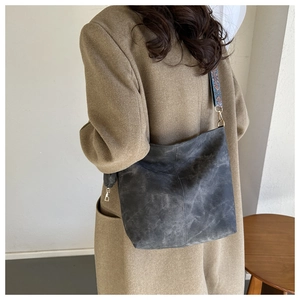 Détail du sac cabas gris avec texture délavée vintage et une bandoulière tissée colorée