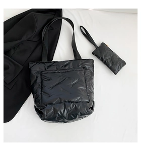 Close-up of quilted down fabric texture on black tote bag with matching small pouch
