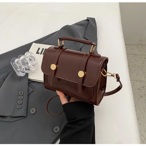 Detailed view of deep brown vintage messenger bag with glossy finish and gold metal accents
