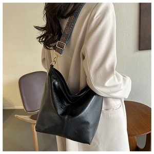 Détail du sac hobo noir avec une bandoulière tissée aux motifs géométriques