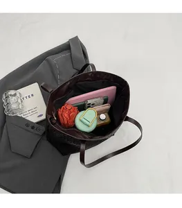 Macro shot of spacious inner compartment in woven leather tote showing tablet storage