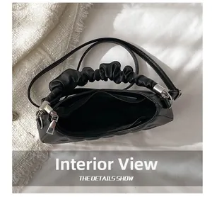 Internal view of the black pleated handbag showing the zipper opening and inner pocket