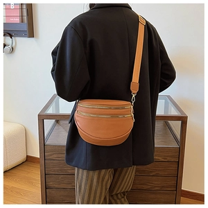 Détail du sac bandoulière demi-lune caramel avec triples zips et large sangle réglable