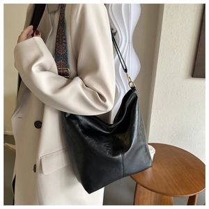 Détail d'un grand sac cabas noir en cuir avec bandoulière large brodée au style ethnique