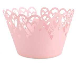 Detailed laser-cut heart patterns on light pink cupcake liners for wedding decor