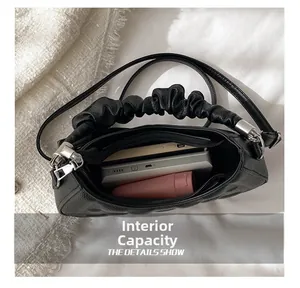 Internal capacity of black leather shoulder bag showing spacious storage for daily items