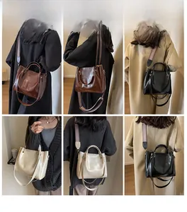 Dettaglio di borse tote multicolore con ampie tracolle testurizzate e fibbie metalliche