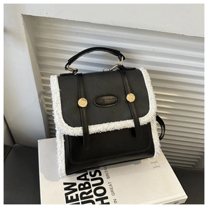 Detail of vintage college style bag with black leather and white sherpa fleece trimming