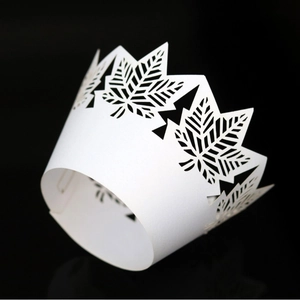 White laser-cut maple leaf lace cupcake wrapper with intricate hollowed-out design