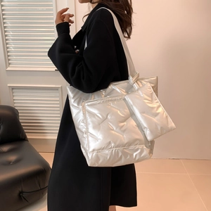 Silver metallic quilted puffer tote bag with a matching pouch shown on a fashion model