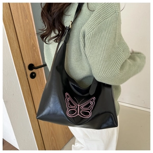 Detail of black PU leather shoulder bag featuring stylish pink butterfly embroidery
