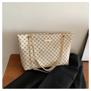 Detail of vintage beige tote bag with rhombus pattern and golden chain straps