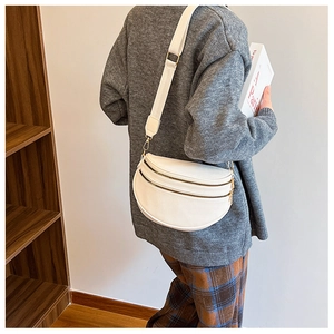 Détail du sac banane blanc texture litchi avec double zip doré et large bandoulière