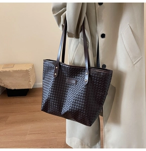 Detailed close-up of dark brown woven leather tote with rectangular fashion label