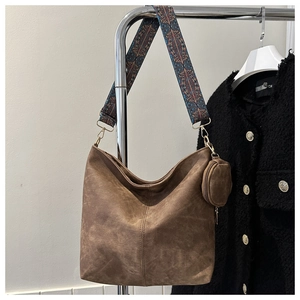 Gros plan sur le sac Hobo en daim marron avec bandoulière géométrique et petit porte-monnaie