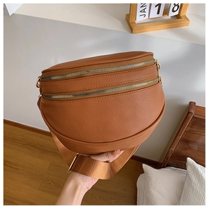 Détail du sac banane en cuir grainé marron avec double fermeture éclair et large bandoulière