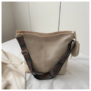 Détail du sac cabas beige avec une large bandoulière ethnique et un mini porte-monnaie