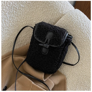 Gros plan du sac bandoulière en peluche noire avec boucle en corne et texture douce