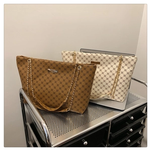 Detail of vintage star pattern tote bags in beige and khaki with chain straps