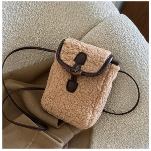 Détail du sac bandoulière en peluche kaki avec boucle en corne et finitions en cuir