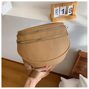 Détail du sac banane marron en cuir grainé avec double fermeture éclair et large bandoulière