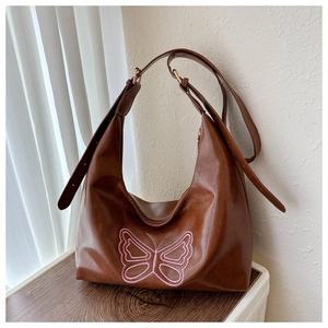Detailed embroidery of pink butterfly on a brown vintage hobo shoulder bag