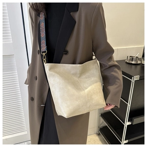 Détail du sac seau en cuir blanc crème avec bandoulière tissée en jacquard coloré