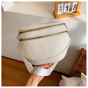 Détail du sac banane blanc en forme de lune avec texture grainée et fermetures dorées