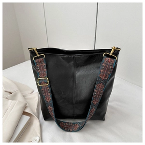Détail d'un grand sac cabas noir avec une bandoulière tissée aux motifs ethniques