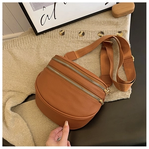 Détail du sac bandoulière en similicuir marron avec doubles fermetures éclair dorées chic